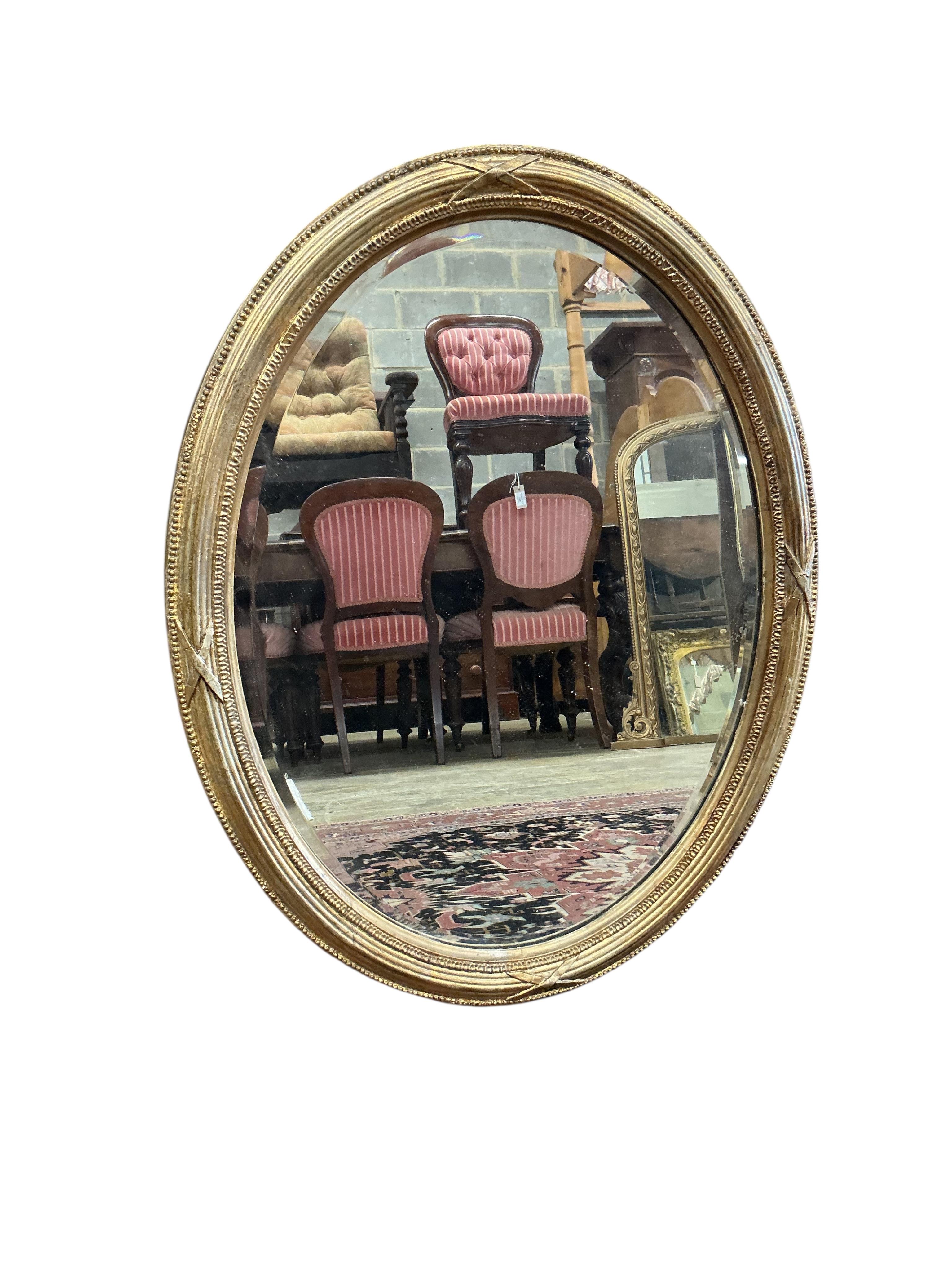 An early 20th century French giltwood and composition circular wall mirror, diameter 51cm, together with an Edwardian oval bevelled mirror and a Regency style wall mirror